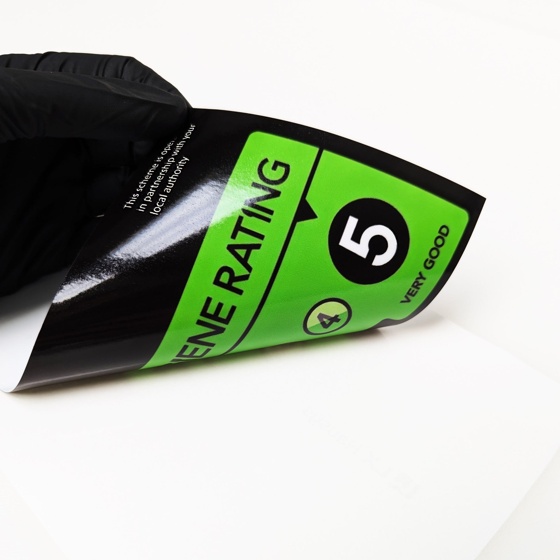 Food hygiene label being peeled off the backing sheet. Image is to show the adhesive side of the sticker.