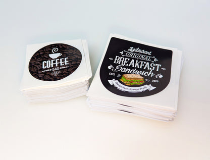 Custom printed self adhesive labels stacked in to 2 separate piles. Product image for Kraken Signs.